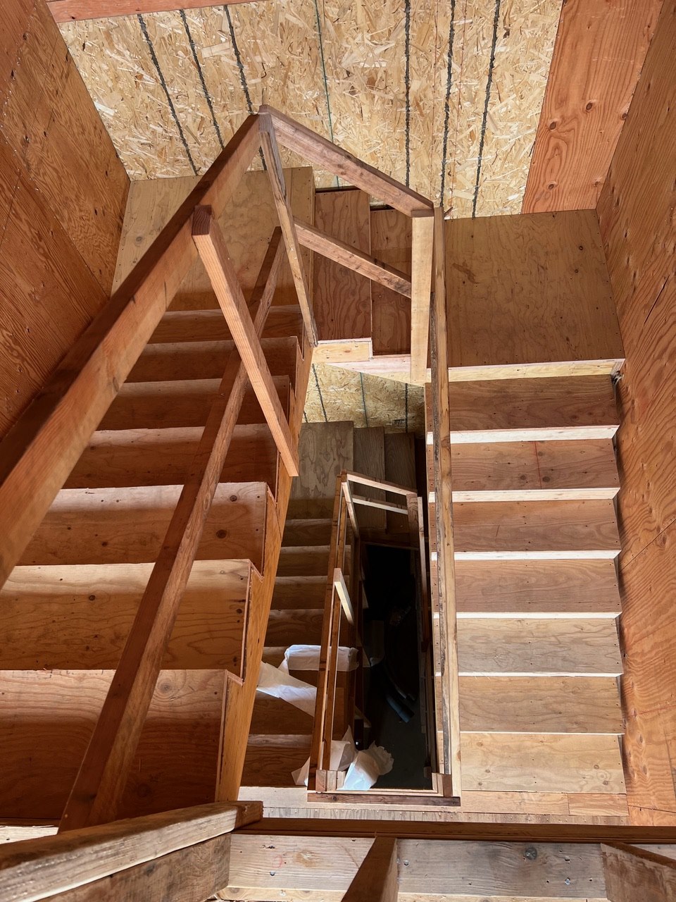 Interior redwood framing and stair stringers under construction