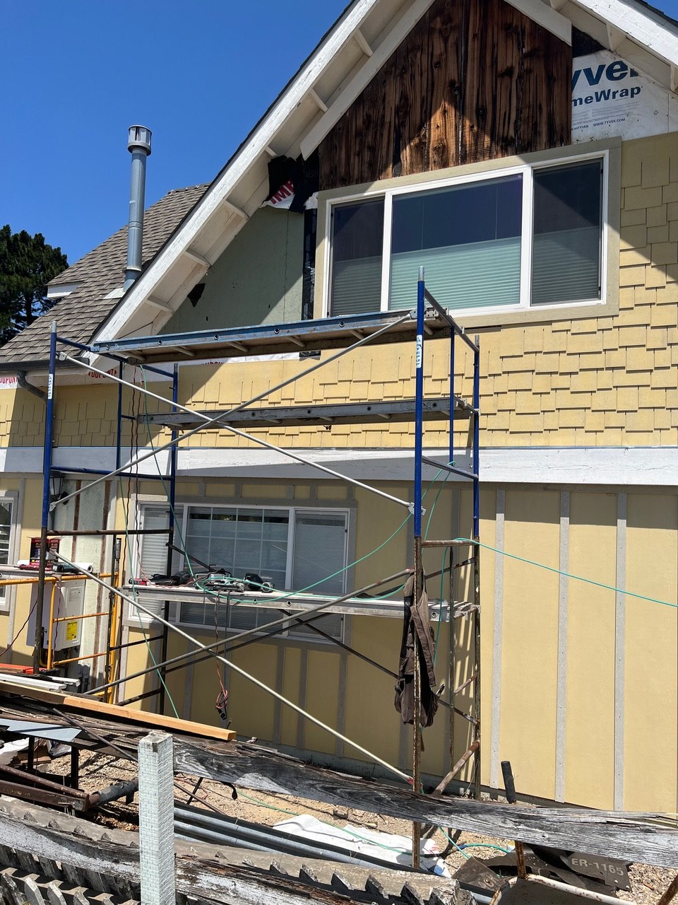 Exterior siding and shingle work in progress with scaffolding